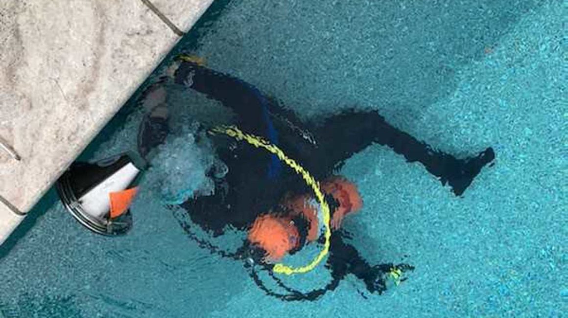 man in scuba gear looking for leaks in pool