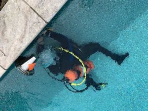 man in scuba gear looking for leaks in pool